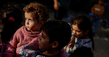 Palestinian children wait to receive food outside their house, which was destroyed by Israeli air strikes, in the northern Gaza Strip, May 15, 2023. (Reuters File Photo)