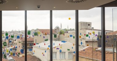 The characters drawn by cartoonist Cem Dinlenmiş adorn a window, Istanbul, Türkiye, May 23, 2023. (Photo courtesy of Salt Galata)