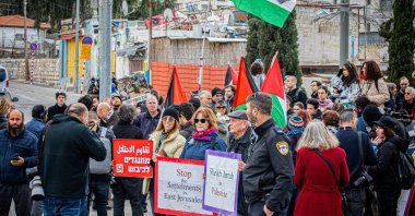 A photographer clicks a photo of Israeli and Palestinian activists singing and waving Palestinian flags during a demonstration at the Sheikh Jarrah neighborhood, East Jerusalem, occupied Palestine, Jan 13, 2023. (Getty Images Photo)