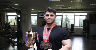 Emrullah Atmaca poses for a photo with his medals and trophy at the Tekirdağ Namık Kemal University (NKU), Tekirdağ, Türkiye, May 11, 2023. (AA Photo)