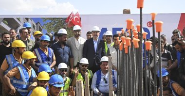 Interior Minister Süleyman Soylu (C) poses with a construction crew at the groundbreaking ceremony for the Voluntary, Safe, Honorable Return Project in Jarablus, northern Syria, May 24, 2023. (AA Photo)