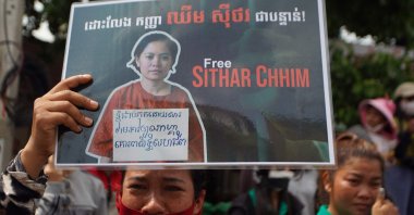 A supporter of Cambodia union leader Chhim Sithar holds up a placard outside Phnom Penh Municipal Court, Phnom Penh, Cambodia, May 25, 2023.(AFP Photo)