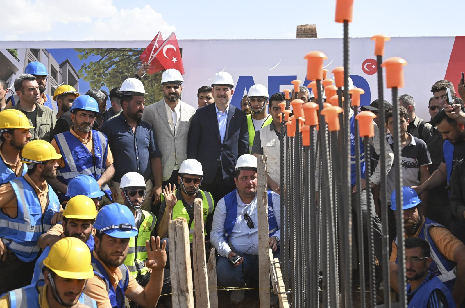 Interior Minister Süleyman Soylu (C) poses with a construction crew at the groundbreaking ceremony for the Voluntary, Safe, Honorable Return Project in Jarablus, northern Syria, May 24, 2023. (AA Photo)