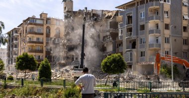 A man watches as excavators demolish a building in Antakya's city center, Hatay, Türkiye, May 4, 2023. (Reuters Photo)
