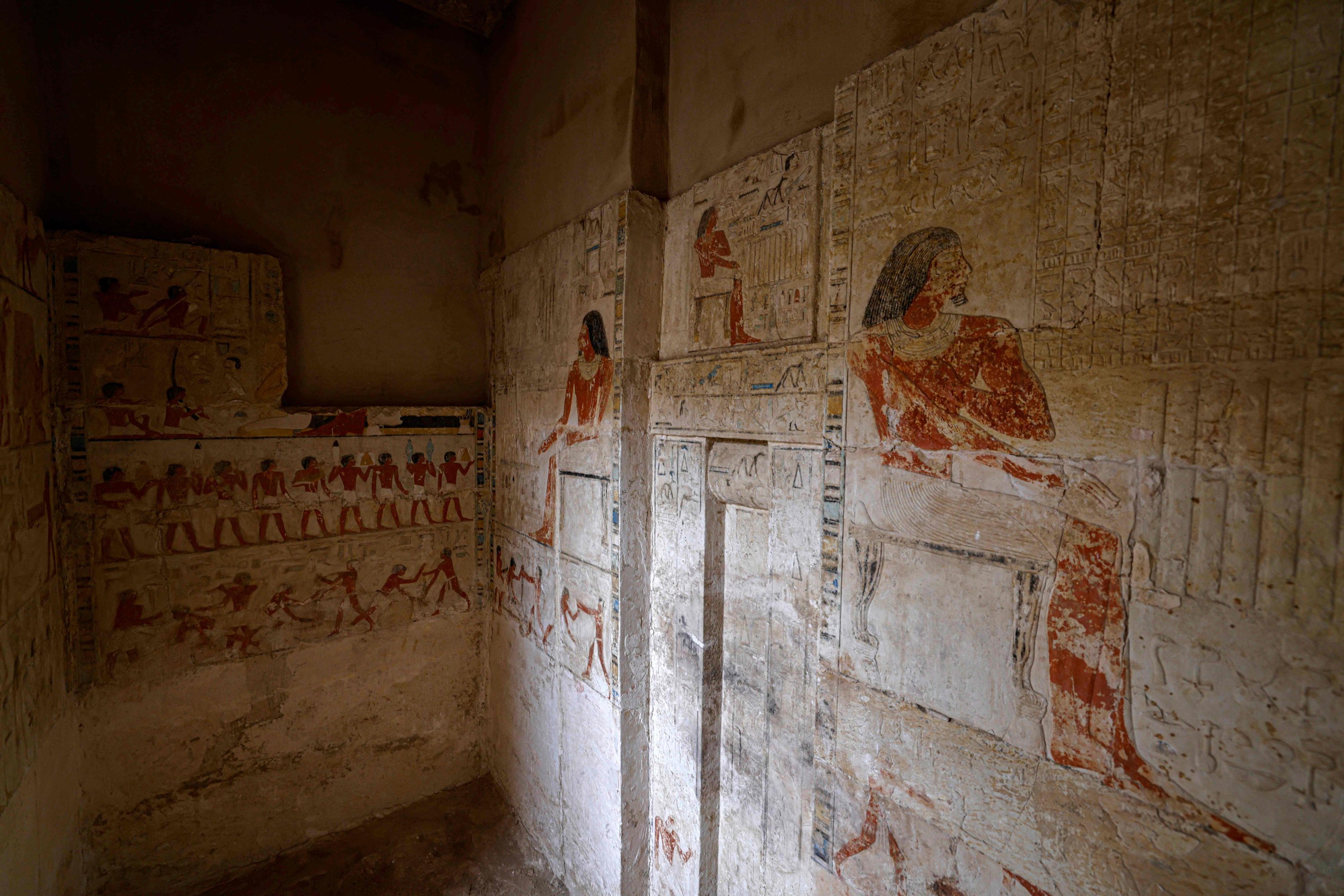 Dinding makam kuno yang baru ditemukan dihiasi dengan lukisan di pekuburan Saqqara di selatan Kairo, tempat para arkeolog menggali dua bengkel pembalseman manusia dan hewan, serta dua makam, 27 Mei 2023. (Foto AFP)