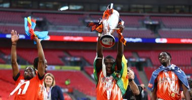 Luton Town&#039;s Zimbabwean midfielder Marvelous Nakamba (C) celebrates with the trophy after winning the Championship playoff final match against Coventry at Wembley Stadium, London, U.K., May 27, 2023. (Reuters Photo)