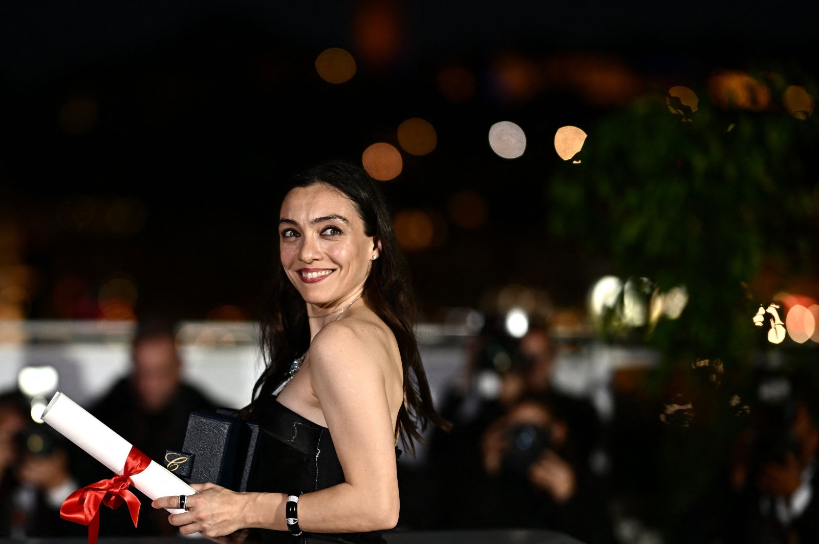 Turkish actress Merve Dizdar poses with her trophy during a photocall after she won the Best Actress Prize for her part in the film &quot;About Dry Grasses,&quot; Cannes, southern France, May 27, 2023. (AFP Photo)