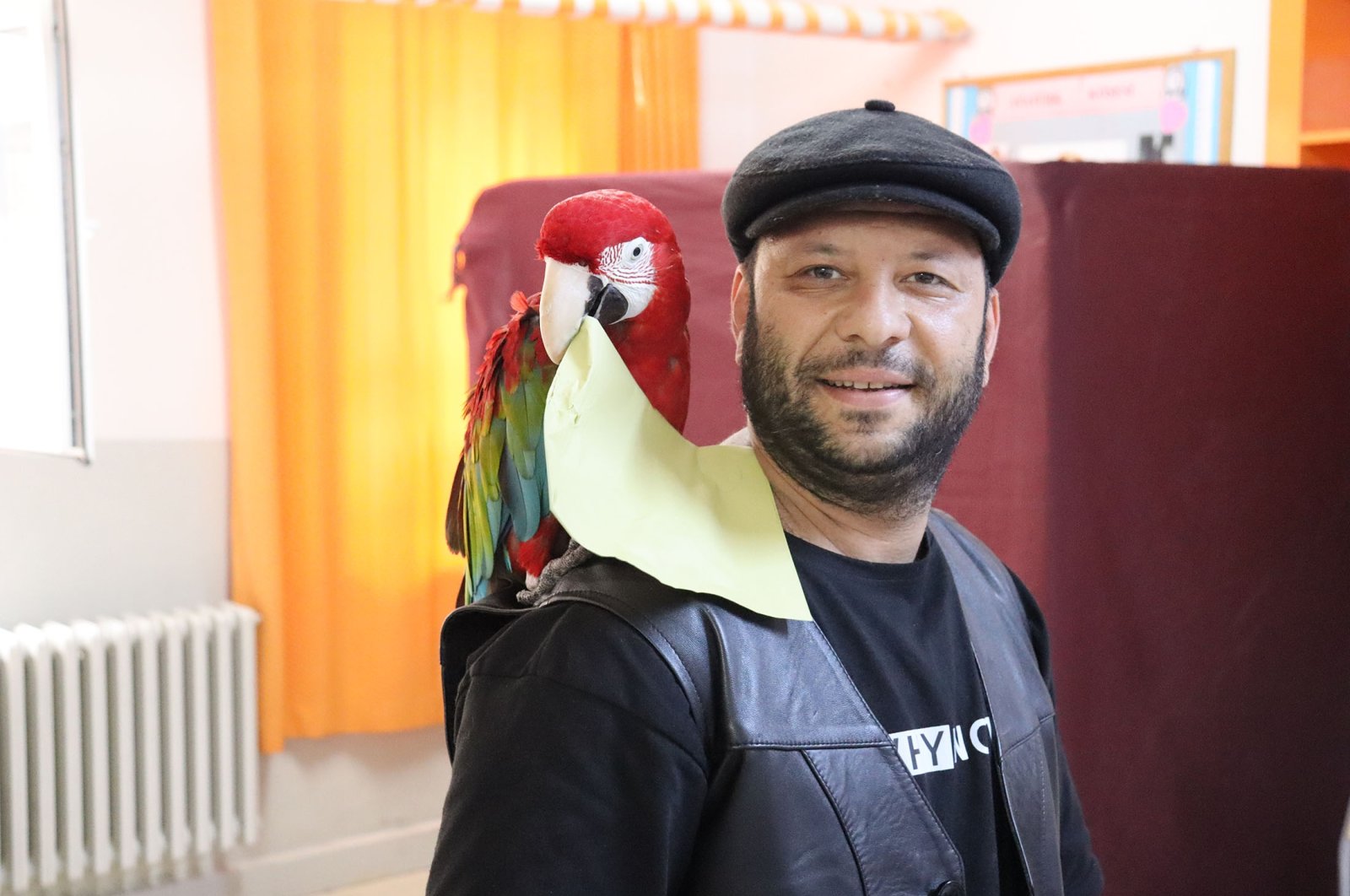 A man lets a parrot on his shoulder carry his ballot, in Denizli, Türkiye, May 28, 2023. (AA Photo)