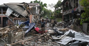 A woman walks through the wreckage of a building vandalized by mobs in Khumujamba village on the outskirts of Churachandpur, Manipur, India, May 9, 2023. (AFP Photo)