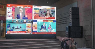 Two men rest on the stairs of CHP headquarters as televisions broadcast election results, in the capital Ankara, Türkiye, May 28, 2023. (AFP Photo)