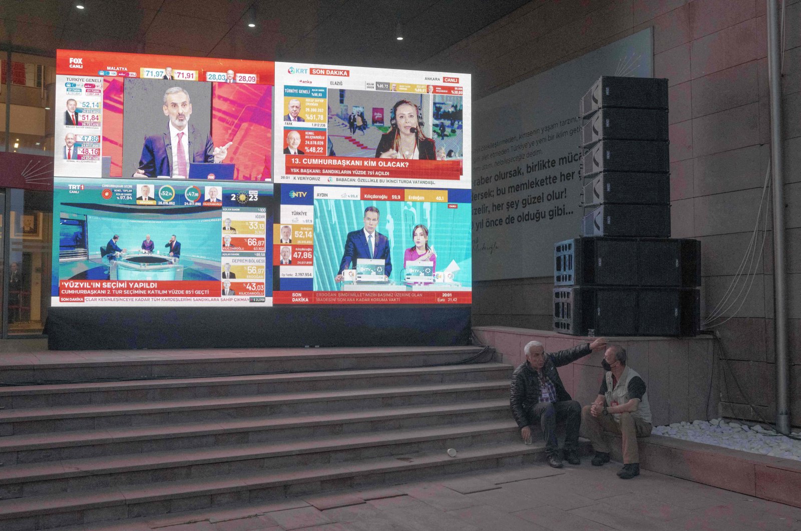 Two men rest on the stairs of CHP headquarters as televisions broadcast election results, in the capital Ankara, Türkiye, May 28, 2023. (AFP Photo)