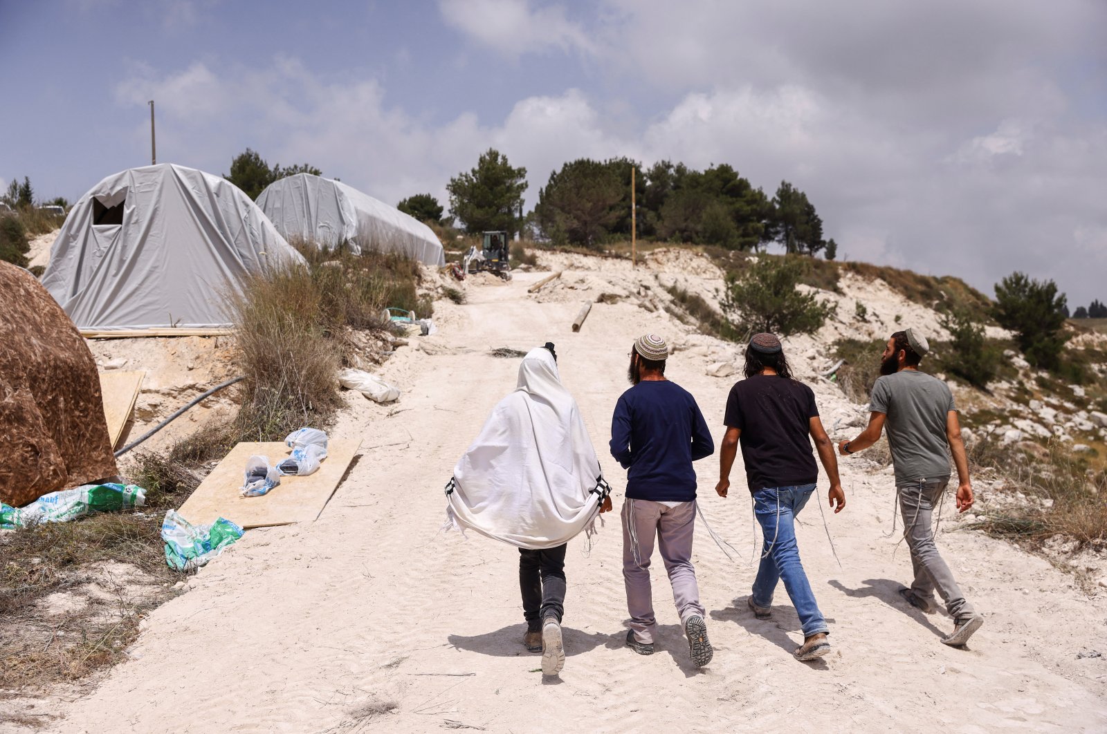 Israeli settlers walk past structures for a new Jewish seminary school in the settler outpost of Homesh, Israeli-occupied West Bank, Palestine, May 29, 2023. (Reuters Photo)