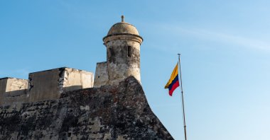 Colombian flag waving on the Spanish colonial era&#039;s castle wall in Cartagena de Indias, Colombia. (Shutterstock Photo)