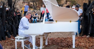 Pianist, Kerem Gorsev playing live open air on a white piano at "The Bodrum Cup" sailing festival for awareness of forest fires, Bodrum, Muğla, Türkiye, Oct. 21, 2021. (Shutterstock Photo)