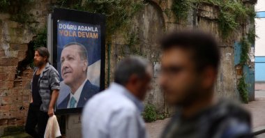 People walk past a sign featuring President Recep Tayyip Erdoğan, after he was declared the winner in the second round of the presidential election, in Istanbul, Türkiye, May 29, 2023. (Reuters Photo)