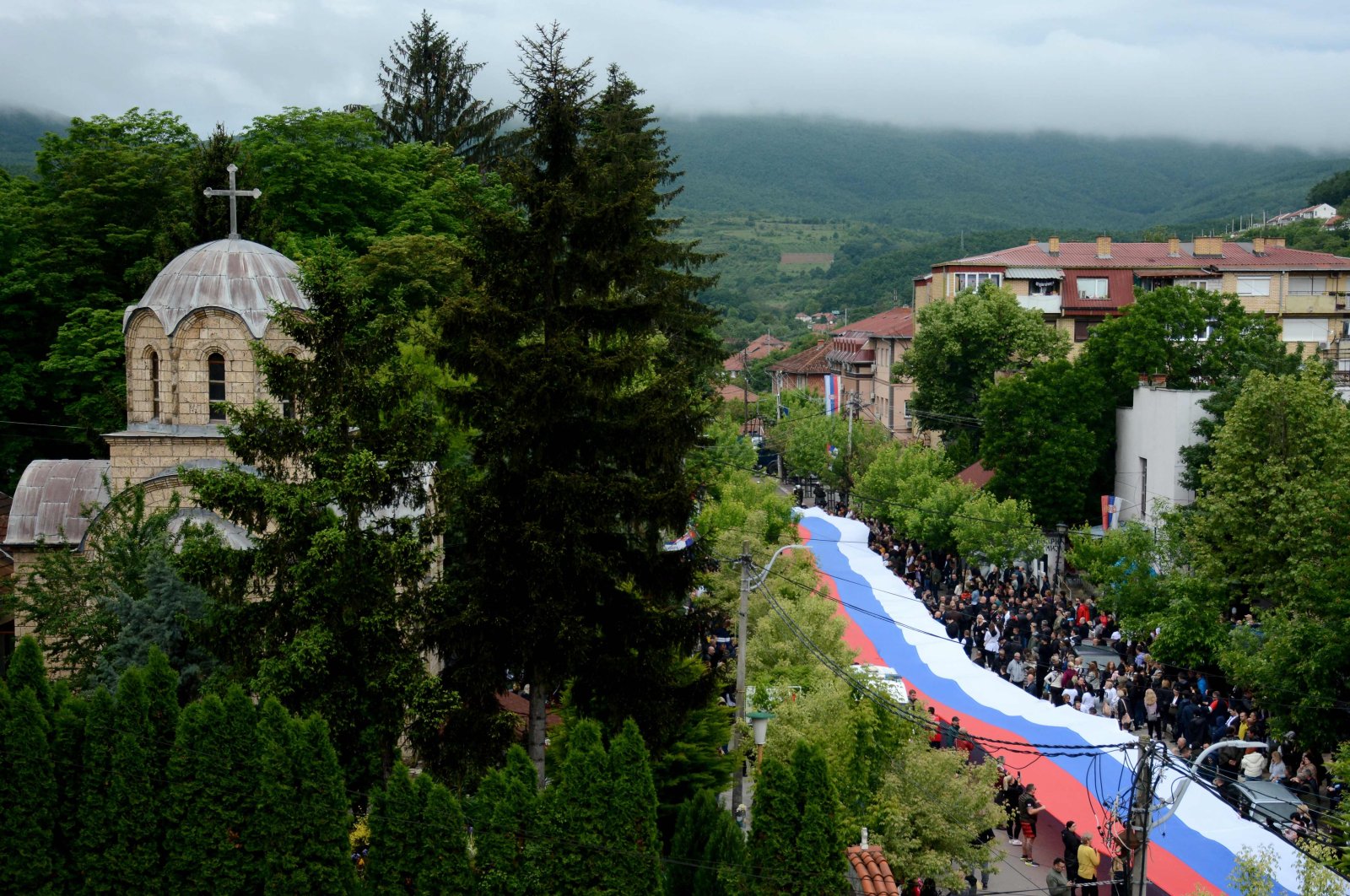 Hundreds of ethnic Serbs carry a giant Serbian flag through the town of Zvecan, in northern Kosovo, May 31, 2023. (AFP Photo)