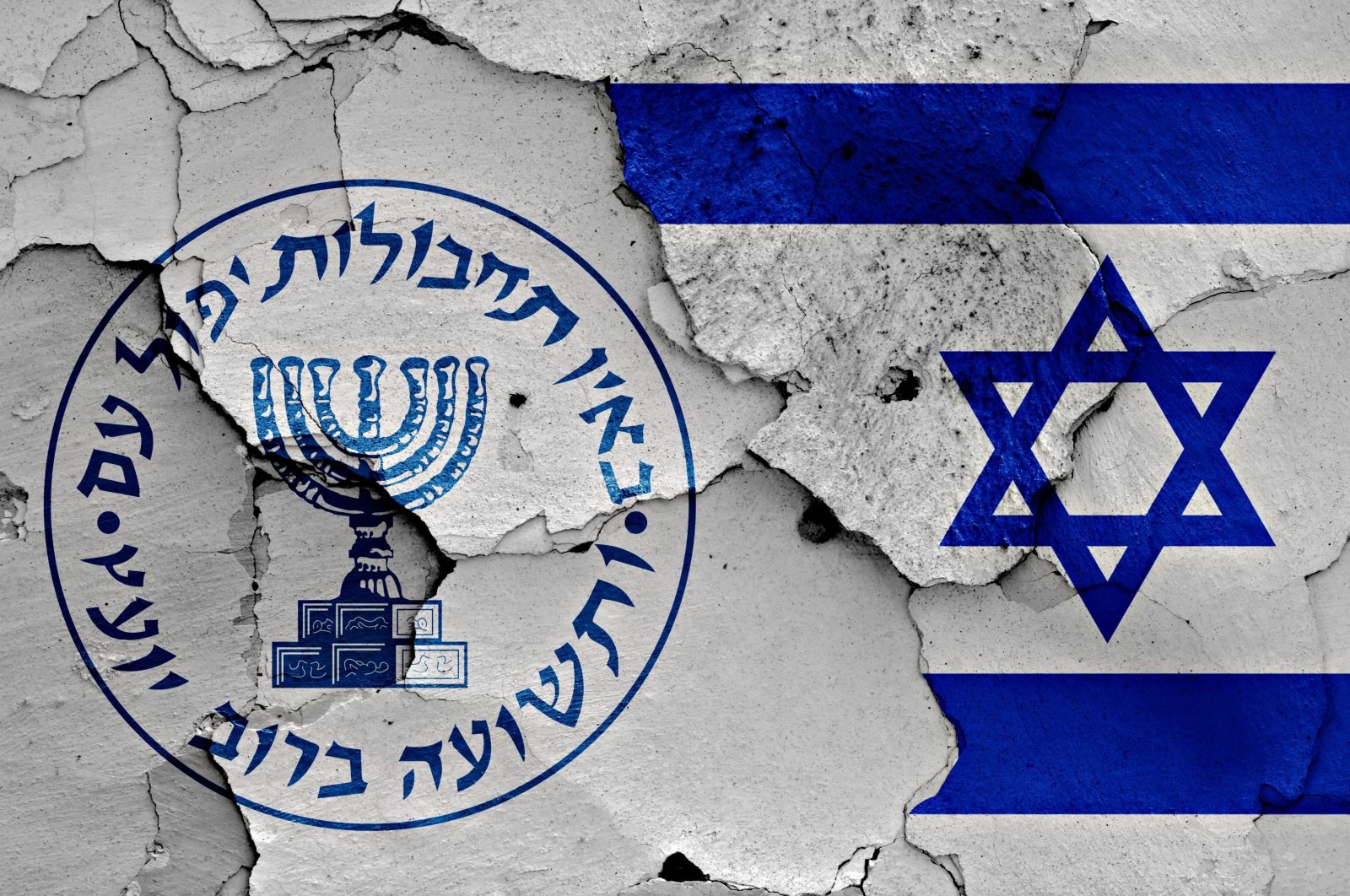 Logo of the Israeli intelligence agency Mossad and the Israeli flag painted on a cracked wall. (Shutterstock Photo)