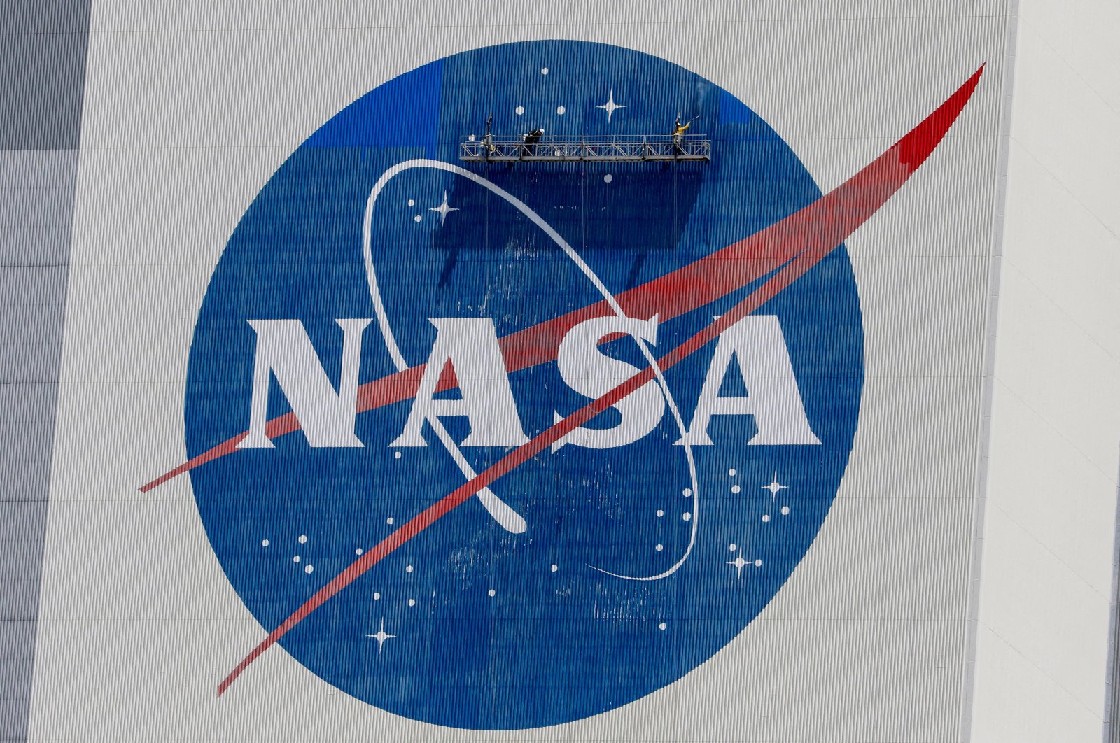Workers pressure wash the logo of NASA on the Vehicle Assembly Building before SpaceX will send two NASA astronauts to the International Space Station aboard its Falcon 9 rocket, at the Kennedy Space Center in Cape Canaveral, Florida, U.S., May 19, 2020. (Reuters File Photo)