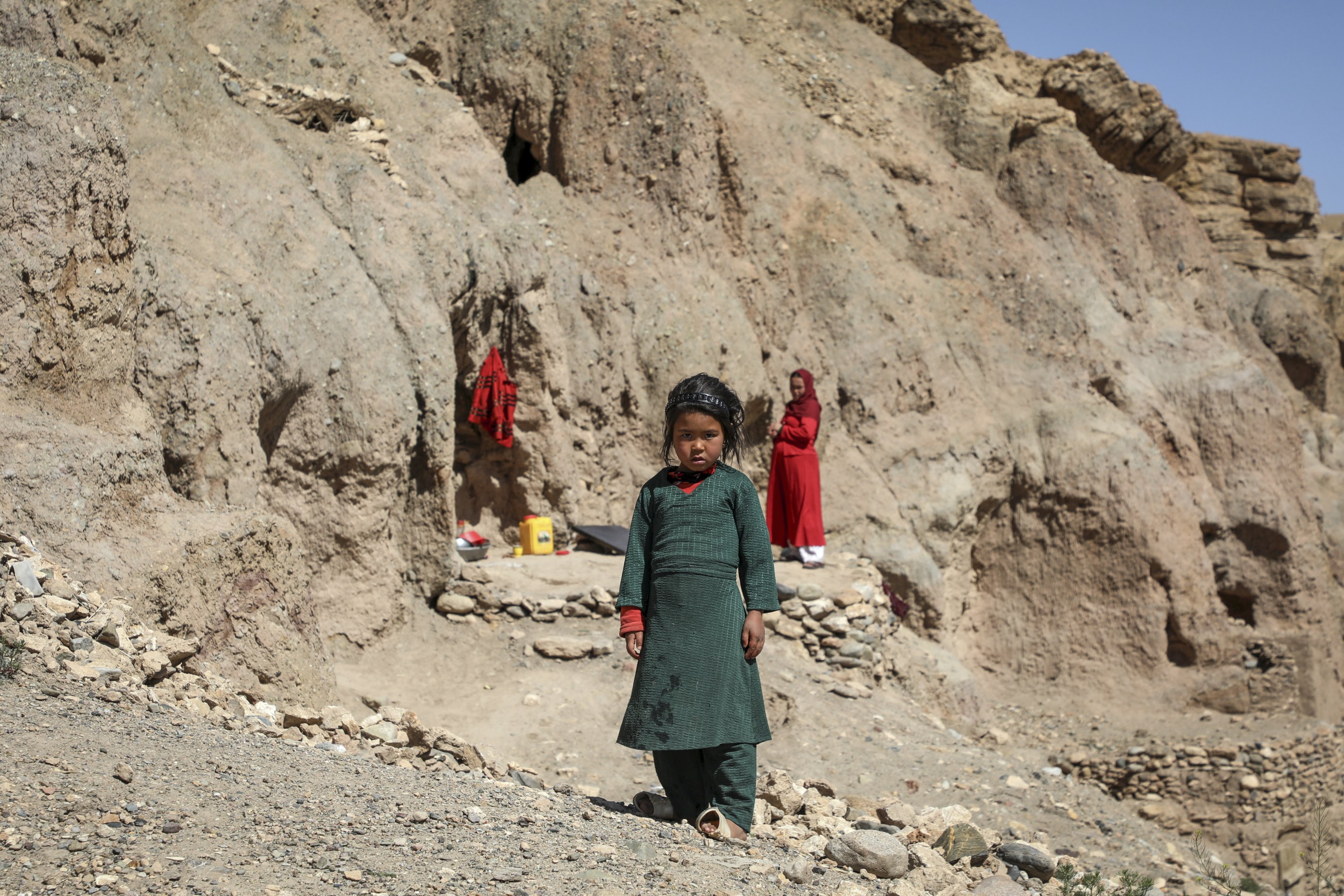 Seorang gadis berpose di depan rumah guanya di Bamyan, Afghanistan tengah, 9 Mei 2023. (Foto AA)