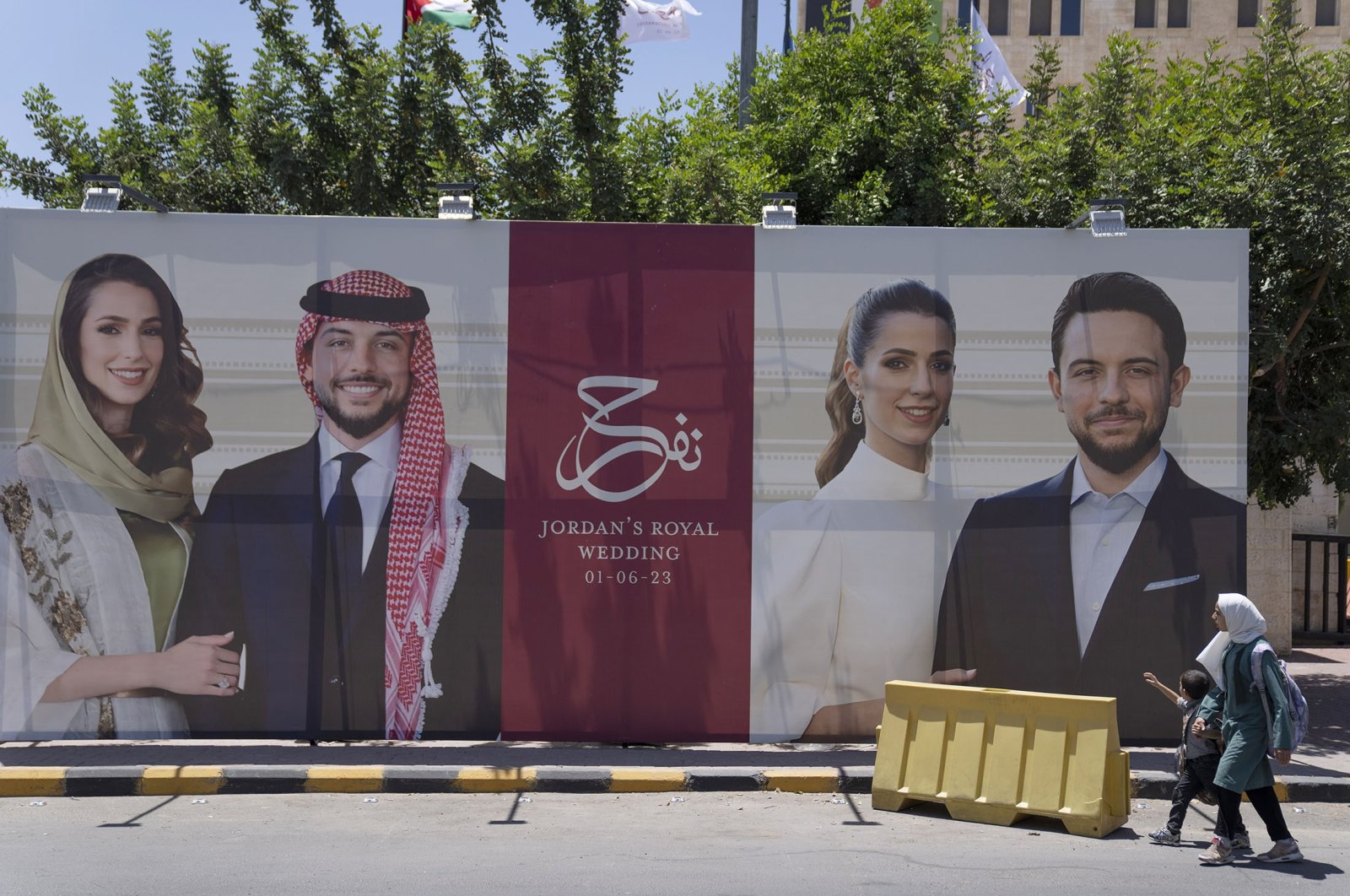 A poster with pictures of Crown Prince Hussein and his fiancee, Saudi architect Rajwa Alseif are displayed near a road in Amman, Jordan, May 31, 2023. (AP Photo)