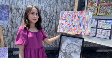 Çiğdem Iyem poses next to some of her paintings, Malatya, Türkiye, June 2, 2023. (AA Photo)