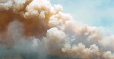 New Brunswick aircraft drops a mix of water and fire retardant as it passes over the wildfire in Barrington Lake, Nova Scotia, Canada in this social media handout image released May 31, 2023. (Nova Scotia Government/Handout via Reuters)