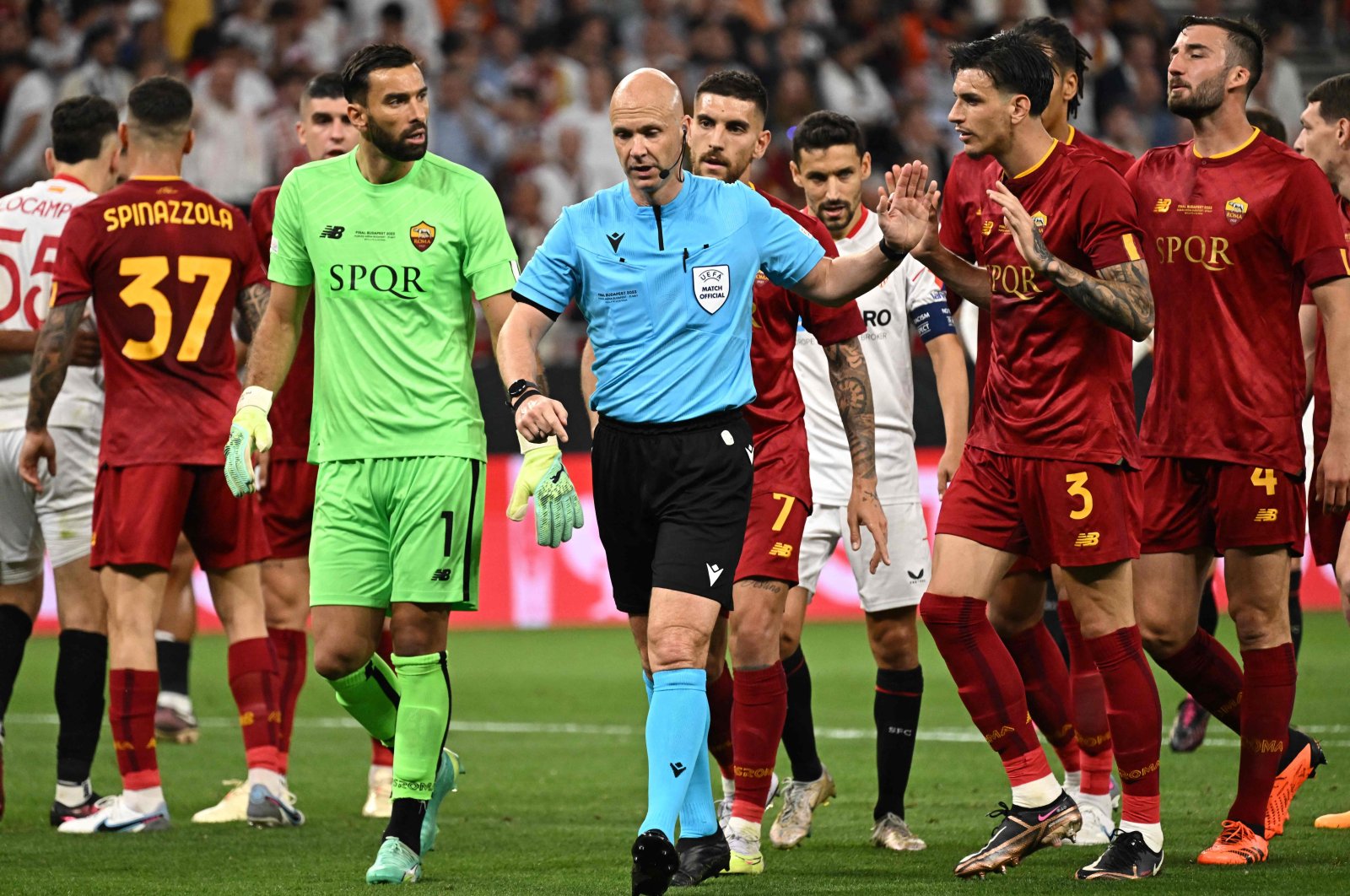 English referee Anthony Taylor (C) passes Roma players as he goes over to the VAR monitor to overturn a penalty decision during the UEFA Europa League final football match between Sevilla FC and AS Roma at the Puskas Arena, Budapest, Hungary, May 31, 2023. (AFP Photo)