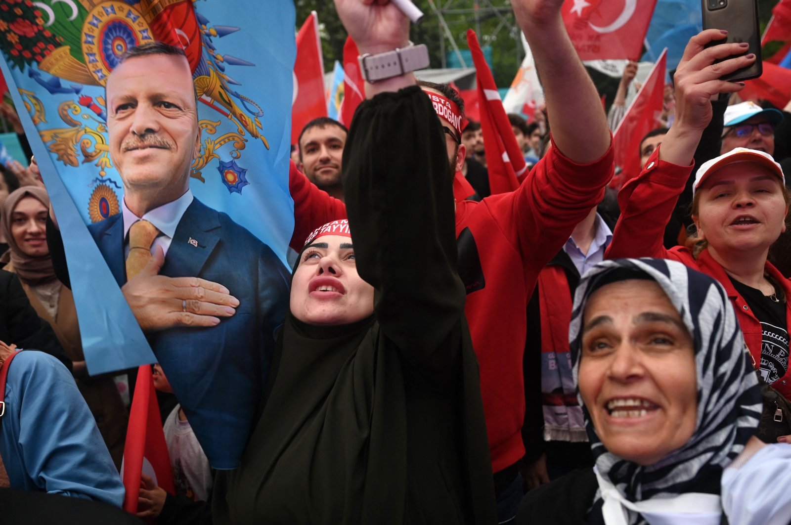 Supporters of President Recep Tayyip Erdoğan wave a flag depicting him in front of AK Party headquarter in Istanbul on the day of the Presidential runoff vote in Istanbul, May 28, 2023. (AFP Photo)