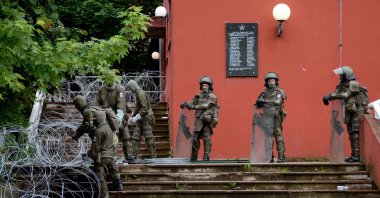 NATO-led Kosovo Force (KFOR) soldiers, wearing full riot gear, place barbed wire around the municipal building in Zvecan following clashes with Serb protesters demanding the removal of recently elected Albanian Mayors, northern Kosovo, May 31, 2023. (AFP Photo)