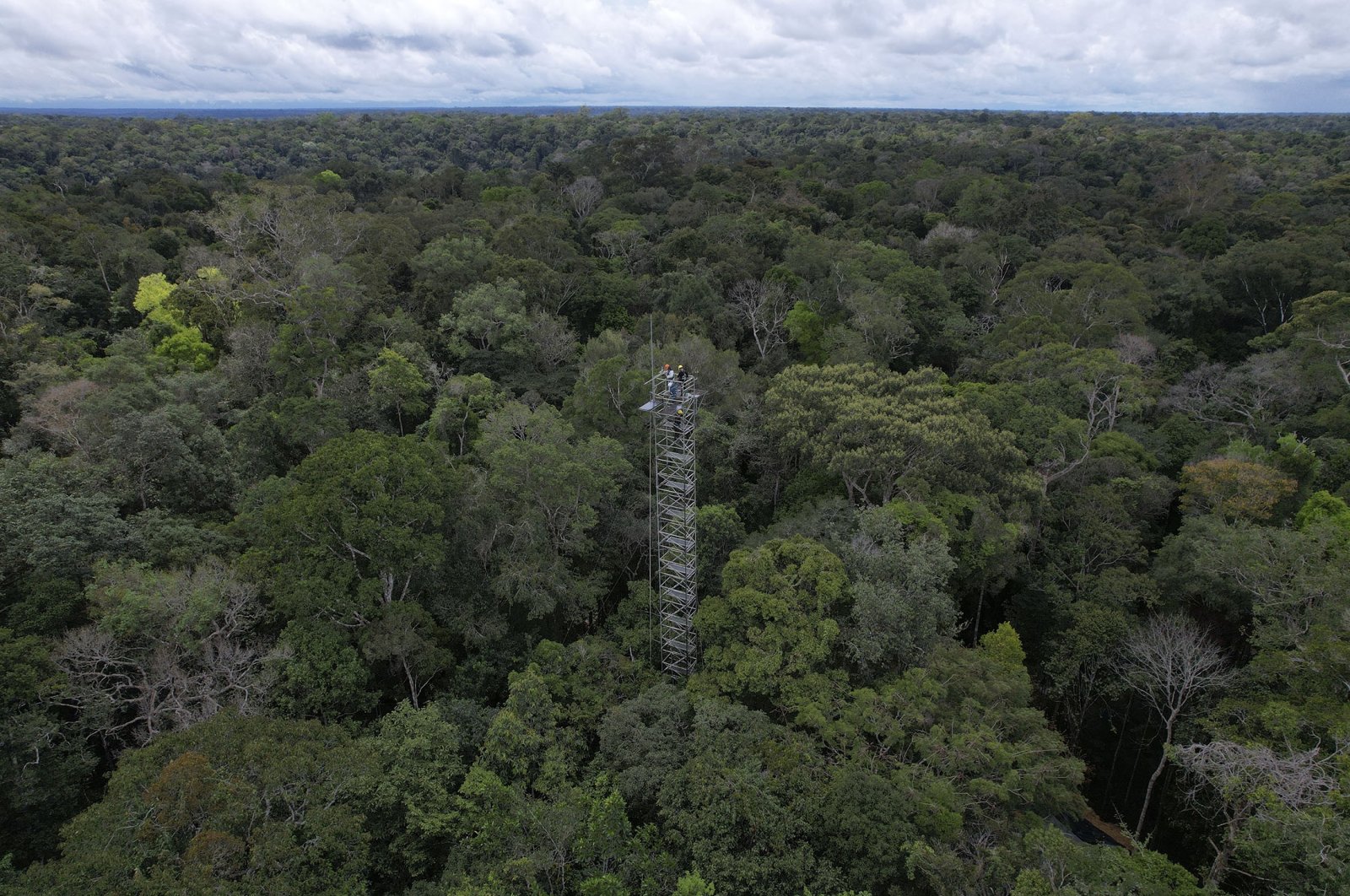 Workers survey a tower that will be part of a complex of towers arrayed in six rings to spray carbon dioxide into the rainforest north of Manaus, Brazil, May 23, 2023. (AP Photo)