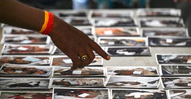A victim's family member looks at photographs to identify the body at a temporary mortuary near Balasore, Odisha, India, June 4, 2023. (AFP Photo)