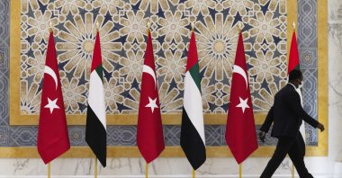An official walks past Turkish and Emirati flags at Qasr Al-Watan in Abu Dhabi, United Arab Emirates, Monday, Feb. 14, 2022. (AP File Photo)