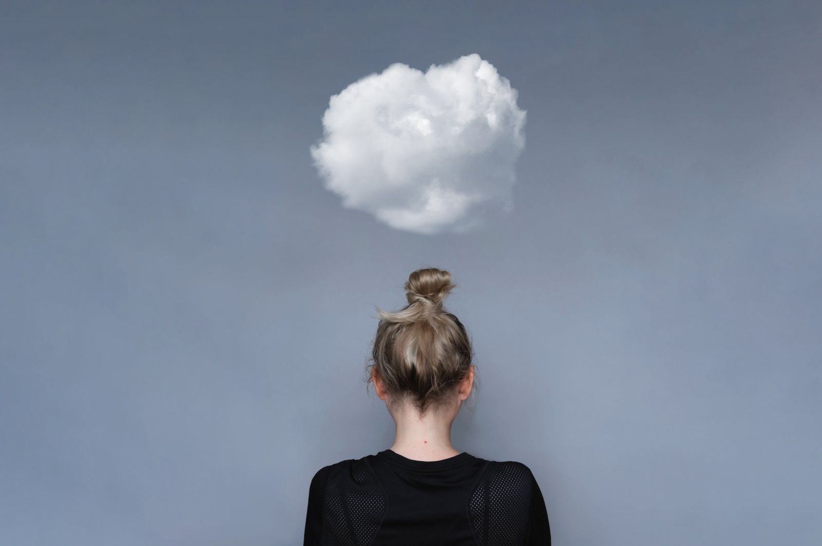 A woman facing back with a cloud over her head, symbolizing her mental health. (Shutterstock Photo)