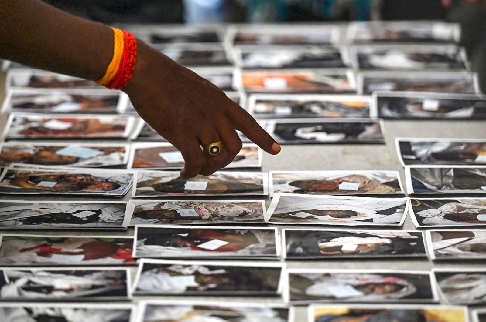 A victim&#039;s family member looks at photographs to identify the body at a temporary mortuary near Balasore, Odisha, India, June 4, 2023. (AFP Photo)