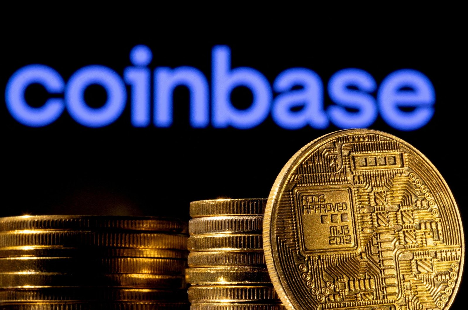 A representation of cryptocurrency in front of Coinbase logo in an illustration, March 4, 2022. (Reuters Photo)