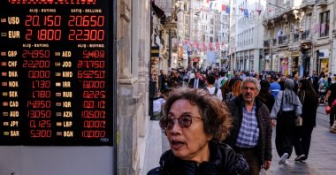 A woman checks currency rates on a digital currency rate board at an exchange office in Istanbul, Türkiye, May 22, 2023. (EPA Photo)