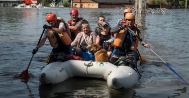 Rescuers evacuate local residents from a flooded area after the Nova Kakhovka dam breached in Kherson, Ukraine, June 7, 2023. (Reuters Photo)