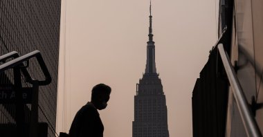 The Empire State Building stands in the background as a person wearing a mask walks on a hazy morning due to smoke from wildfires burning in Canada, in New York, U.S., June 7, 2023. (EPA Photo)