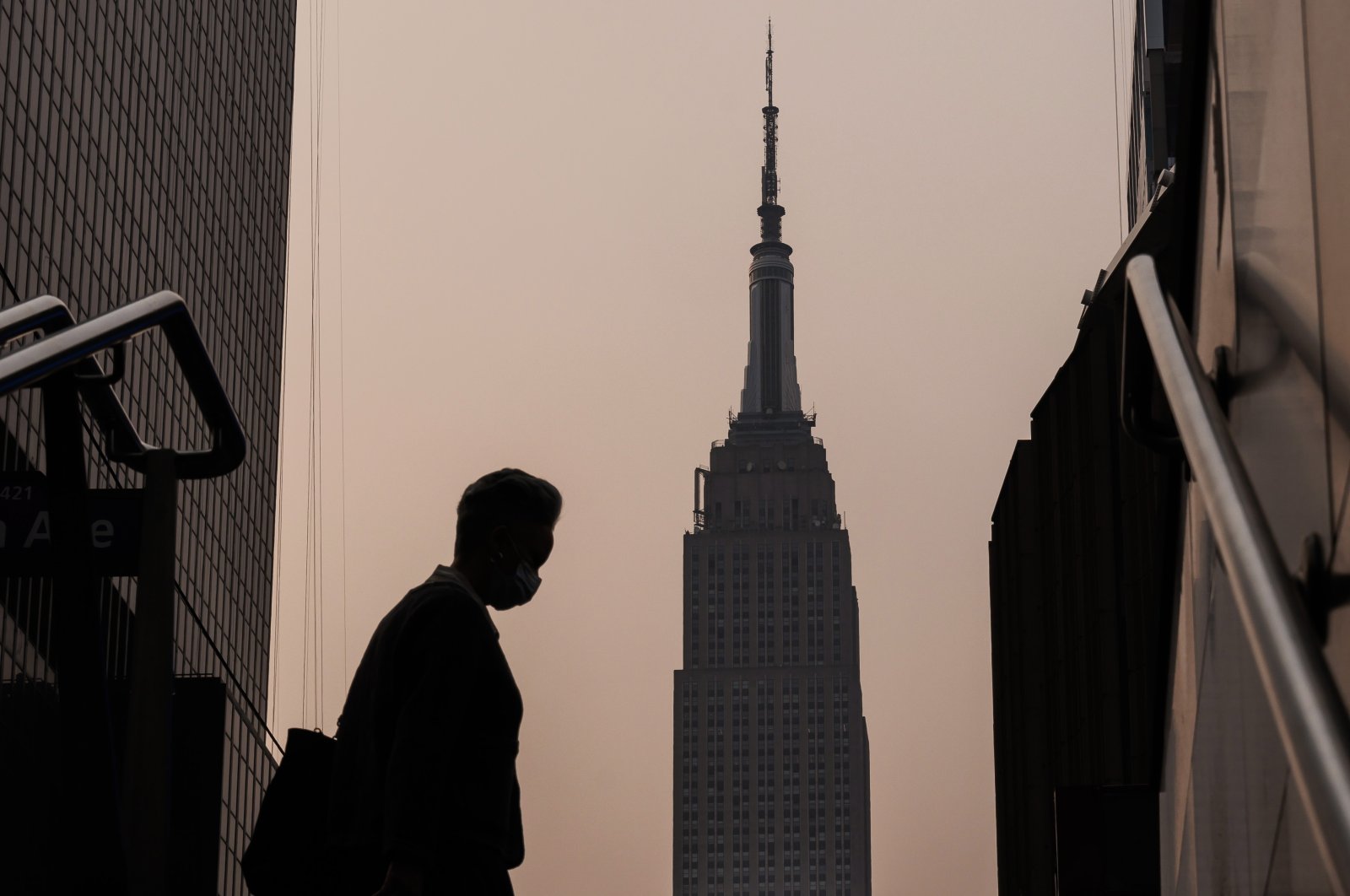 The Empire State Building stands in the background as a person wearing a mask walks on a hazy morning due to smoke from wildfires burning in Canada, in New York, U.S., June 7, 2023. (EPA Photo)