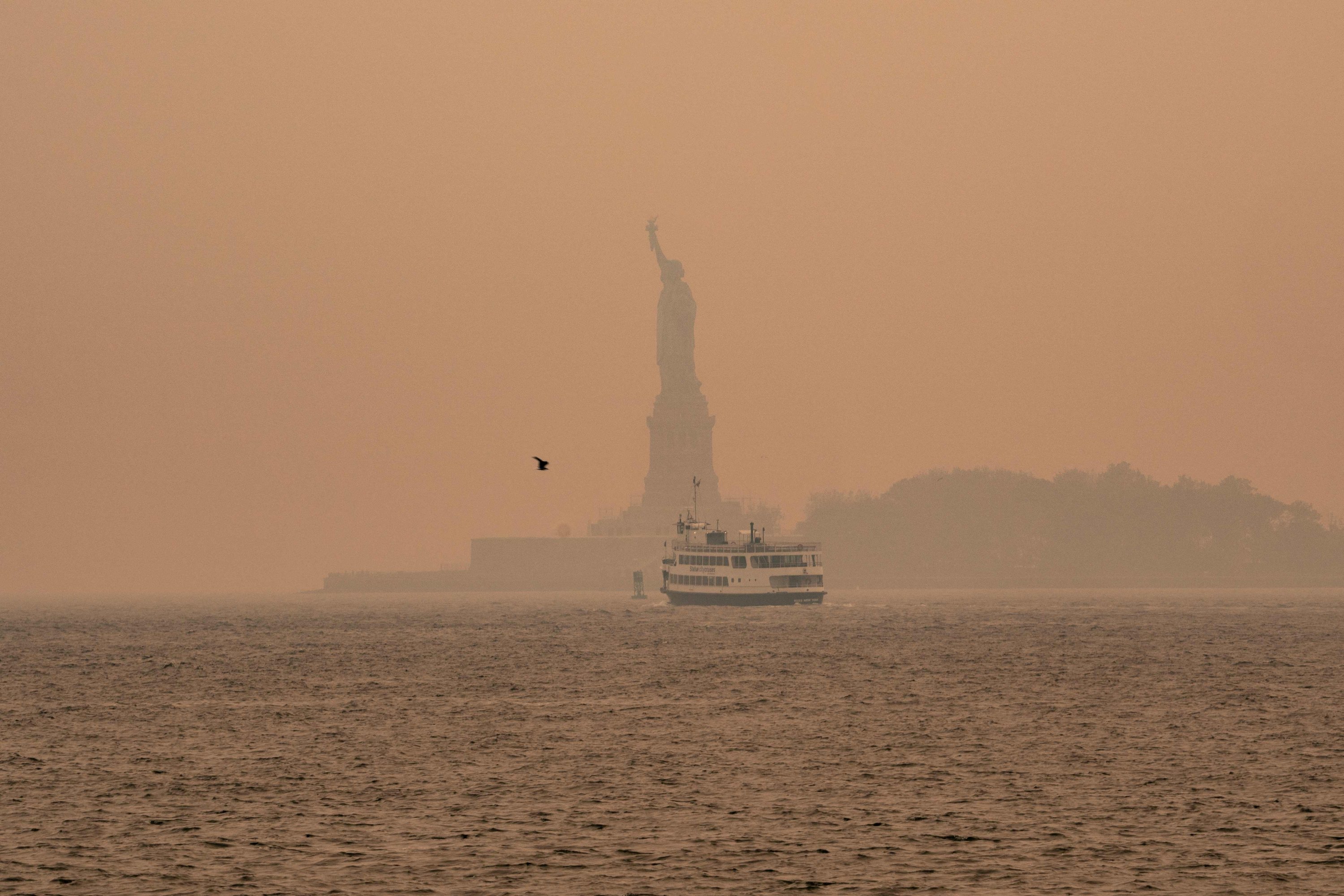 Kabut berasap dari kebakaran hutan di Kanada menyelimuti Patung Liberty, Kota New York, AS, 7 Juni 2023. (Foto AFP)