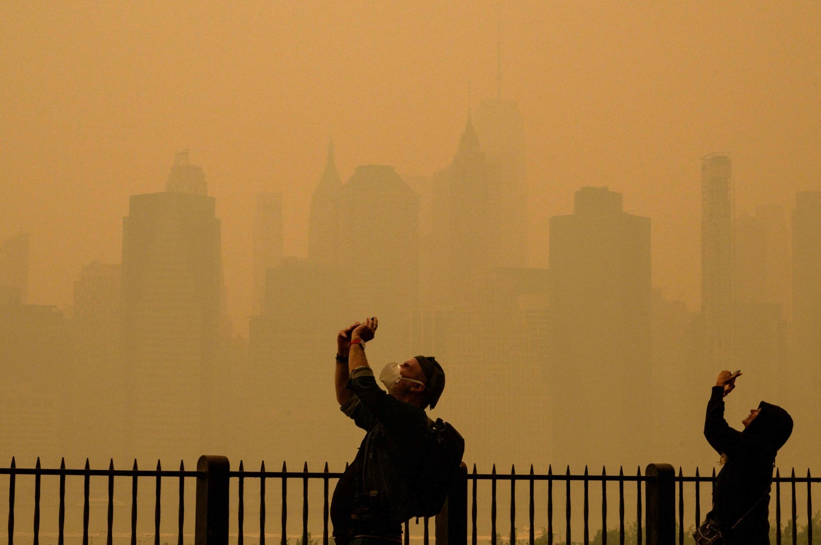 People take photos of the sun as smog causes hazy conditions in New York City, U.S., June 7, 2023. (AFP Photo)