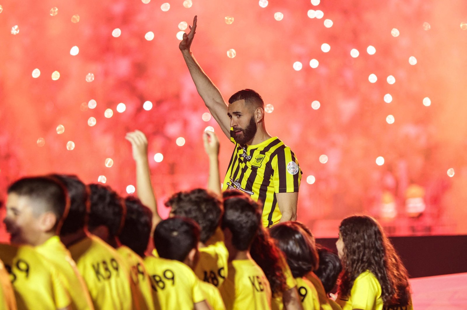 Former Real Madrid striker Karim Benzema, surrounded by children taking part in a ceremony, waves to the crowd at Al-Ittihad&#039;s stadium in Jeddah, Saudi Arabia, June 8, 2023. (AFP Photo)
