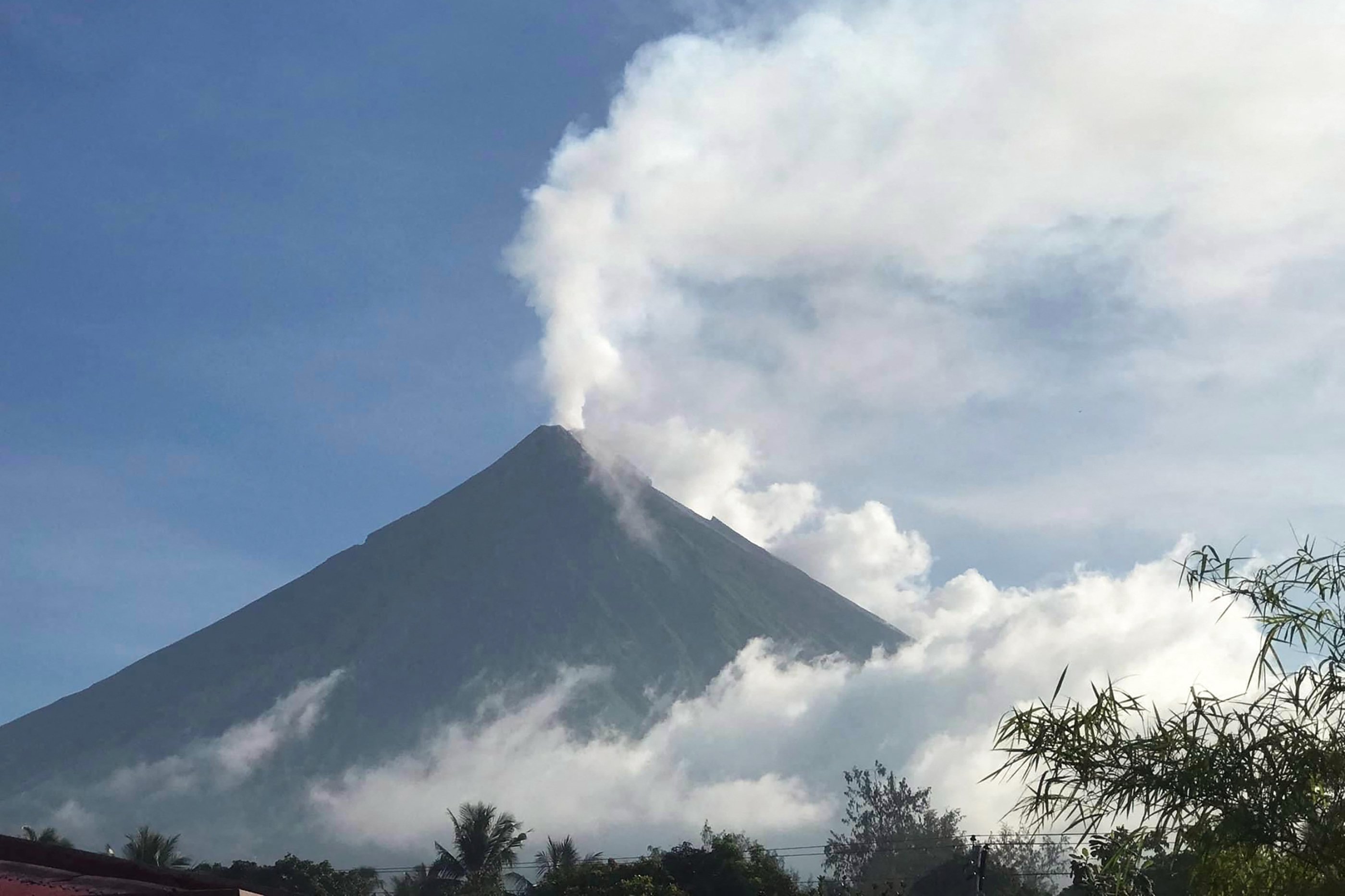 Gunung Mayon menyemburkan asap putih terlihat dari Camalig, Filipina, 8 Juni 2023. (AFP Photo)