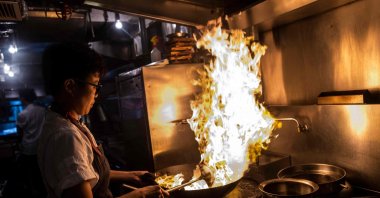 Chef ArChan Chan using a wok inside the kitchen of the Ho Lee Fook restaurant to prepare one of her dishes in Hong Kong, China, May 17, 2023. (AFP Photo)