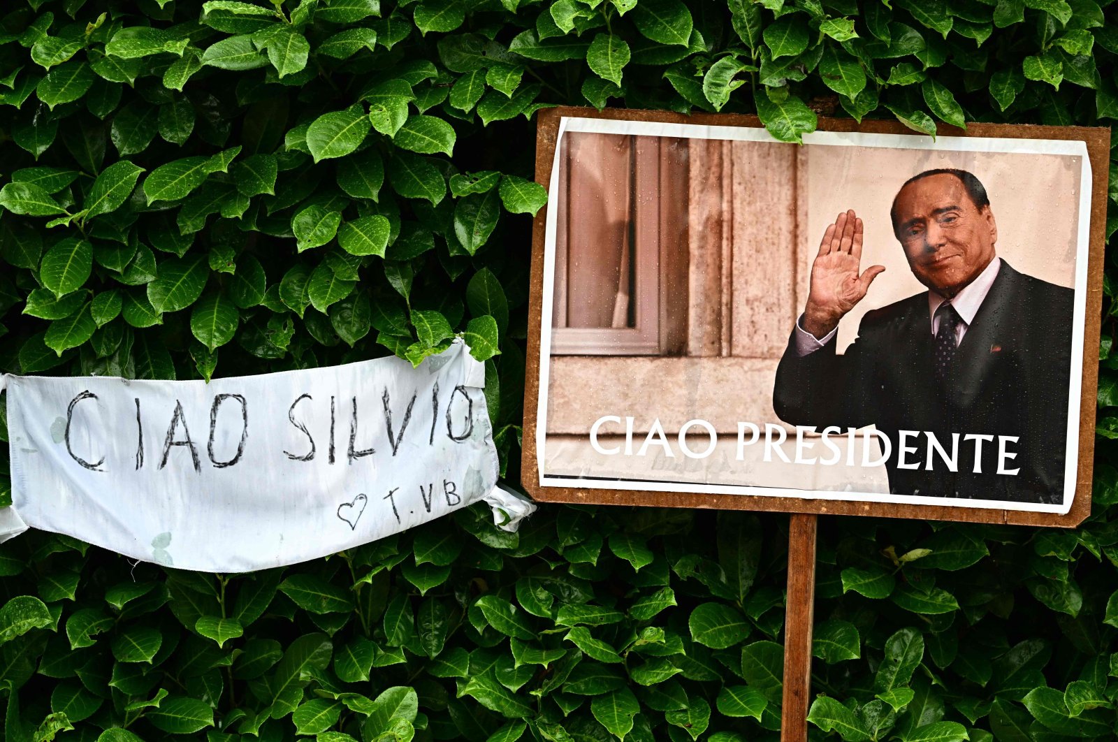 This photograph shows a portrait of Silvio Berlusconi reading "Goodbye, President" outside his residence in Arcore, northern Italy, June 13, 2023. (AFP Photo)