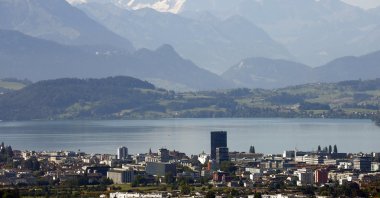 The snow-covered peaks of Bernese Oberland are seen behind Lake Zug and the city of Zug, Switzerland, Aug. 20, 2020. (Reuters Photo)