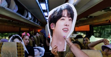 Members of the Australian chapter of K-pop megastars BTS&#039;s global following, known as ARMY, pass around cardboard cutouts of the group while on a coach during their 12-day &quot;BTS tour&quot; to mark the 10th anniversary of the group&#039;s debut, Seoul, South Korea, June 13, 2023. (AFP Photo)