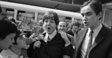 Fans surround Beatles Paul McCartney (C) and George Harrison (2R) upon their arrival at Orly airport, Paris, France, June 20, 1965. (AFP Photo)