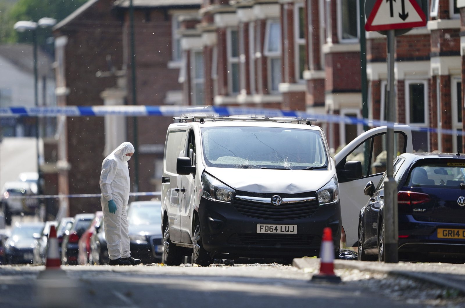 A police forensic officer searches a white van behind a police cordon in Nottingham city center, U.K., June 13, 2023. (AP Photo)