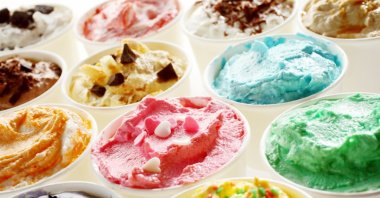 Display of tasty summer ice cream in different flavors and colors served in individual tubs. (Shutterstock Photo)